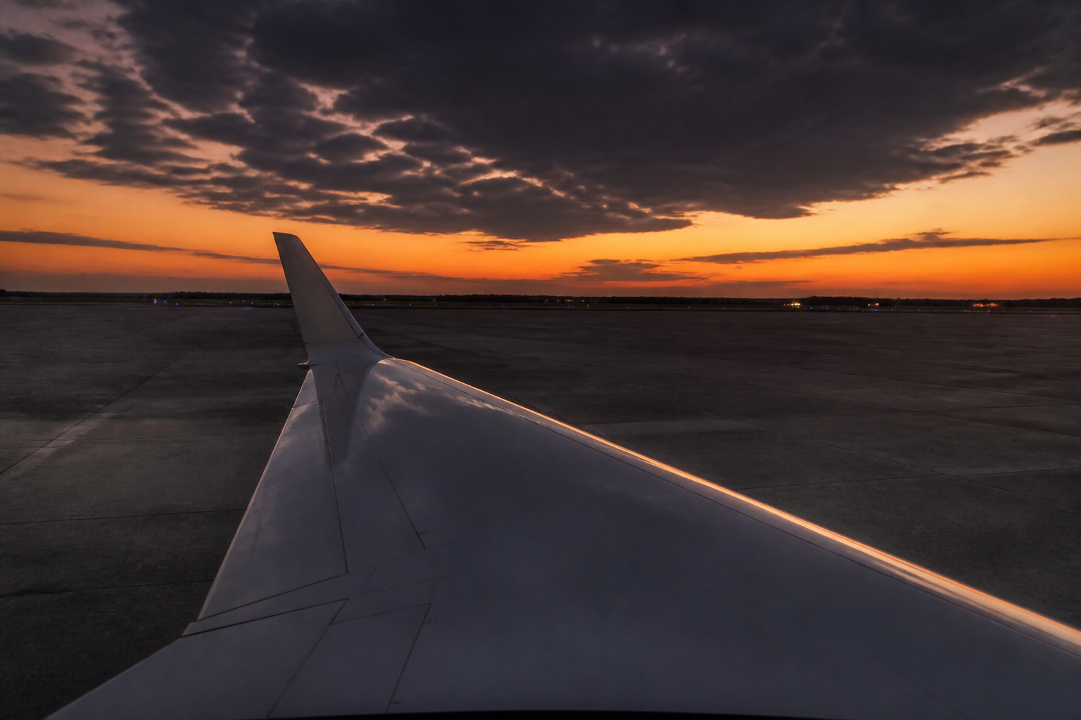 Empty leg vs full charter: private jet wing on a quiet tarmac at dusk during repositioning